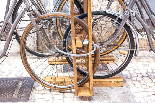 Row of parked vintage bicycles bikes for rent in Old town. Wheels are locked