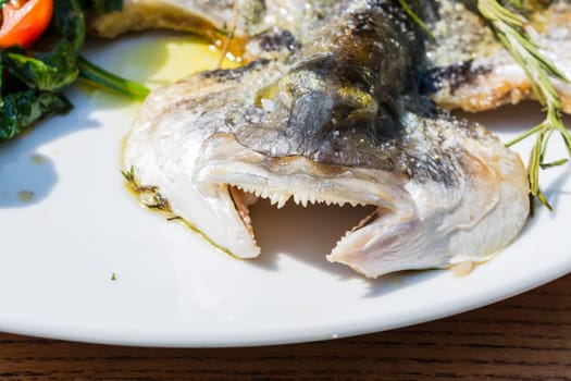 Fresh fish sea bream,sea bream prepared with salt,herbs and pepper,grilled..
