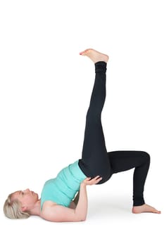 Full body view of a young blonde woman doing yoga exercises against a white background with a slight shadow