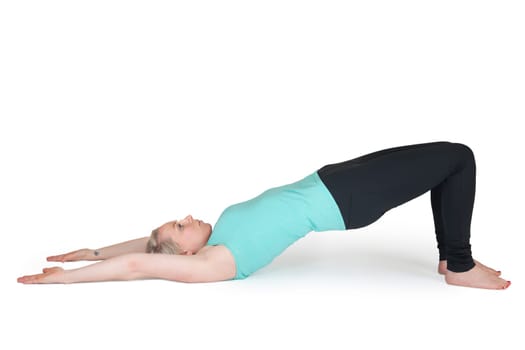 Full body view of a young blonde woman doing yoga exercises against a white background with a slight shadow