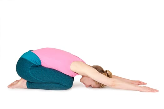 Full body view of a young blonde woman doing yoga exercises against a white background with a slight shadow