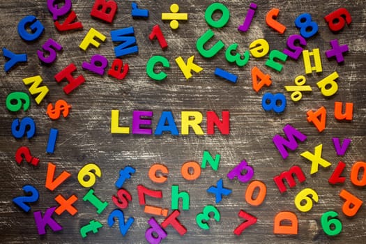 Learn written by plastic colorful letters on a wooden background