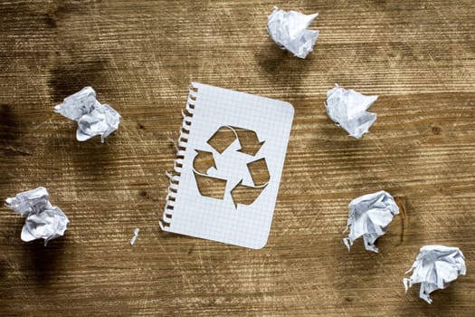 Crumpled paper pieces and paper with recycle sign