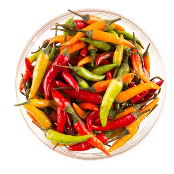Bowl of yellow, red and green hot chili peppers isolated on white.  View from above.