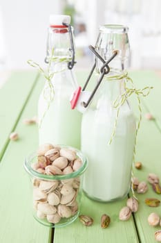 Homemade vegan pistachio milk in old milk bottles