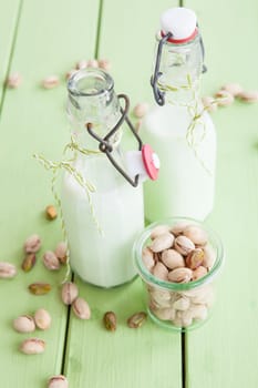 Homemade vegan pistachio milk in old milk bottles
