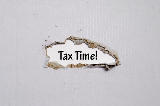The word tax time appearing behind torn paper