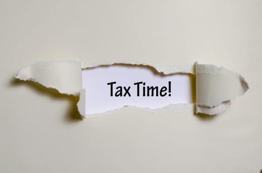 The word tax time appearing behind torn paper