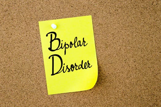 BD Bipolar Disorder written on yellow paper note pinned on cork board with white thumbtacks, copy space available