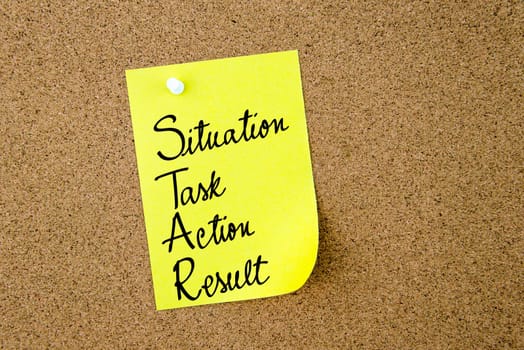 STAR as Situation, Task, Action, Result written on yellow paper note pinned on cork board with white thumbtacks, copy space available