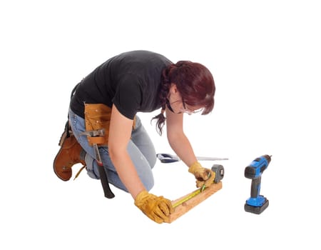 A middle age woman kneeling on the floor and working with some tools.measuring, isolated for white background..