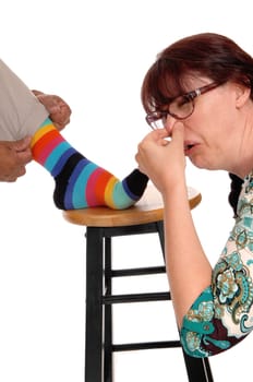 A discussed woman holding her nose closed from the smell of her.husband's socks, isolated for white background..