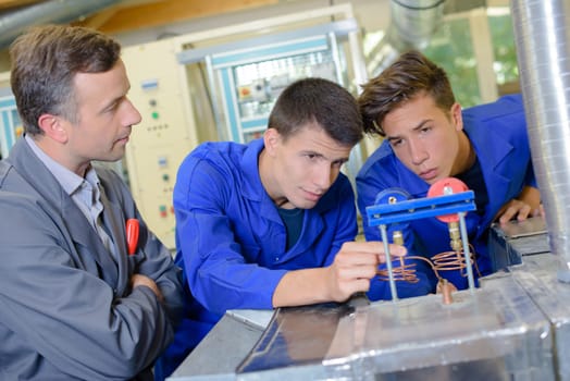 Teacher watching two students using apparatus