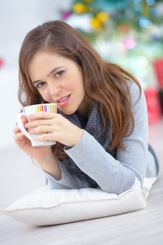 Woman laying on the floor with a cup of coffee