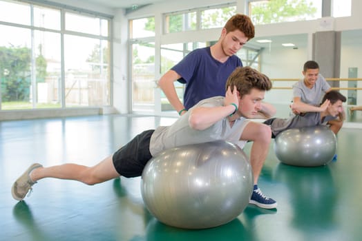 Two men exercising with personal trainers