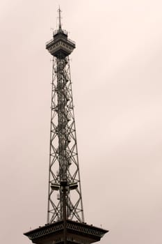 The steel framework of the Berlin Radio Tower against a bey and blurred background.