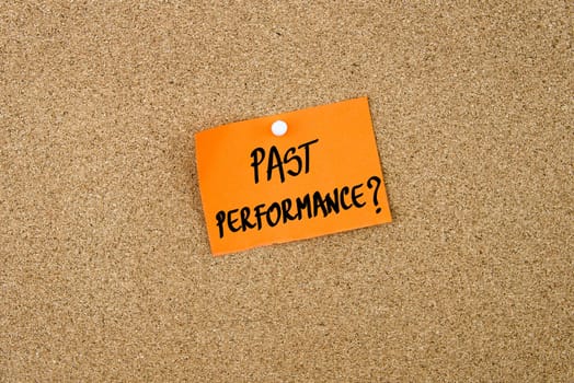 Past Performance written on orange paper note note pinned on cork board with white thumbtack, copy space available