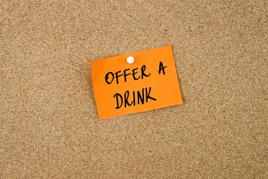 Offer A Drink written on orange paper note note pinned on cork board with white thumbtack, copy space available
