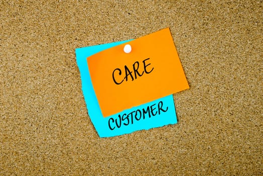 Customer Care written on paper notes pinned on cork board with white thumb tack, copy space available