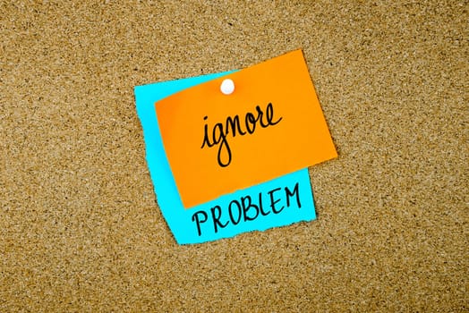 Ignore Problem written on paper notes pinned on cork board with white thumb tack, copy space available