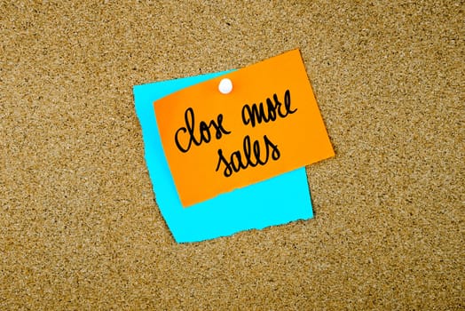 Close More Sales written on paper notes pinned on cork board with white thumb tack, copy space available