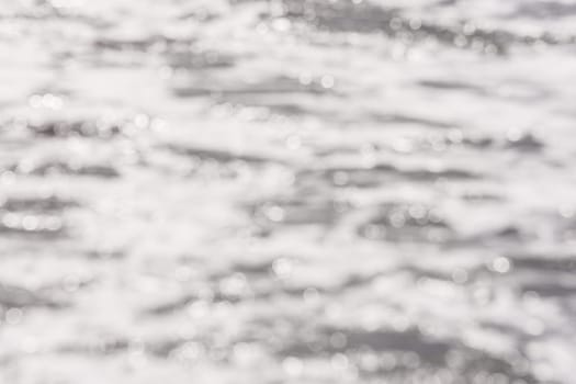 Background - blurred sea surface water with the reflection of sunlight