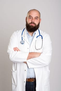 young bearded doctor with crossed arms in white coat