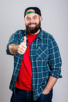 young bearded man with baseball cap with thumb up