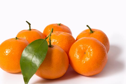 A pile of ripe tangerines with leaves isolated on white background without shadows.