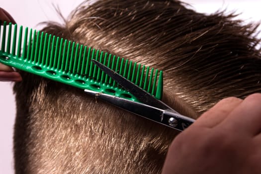 Young man getting haircut from female hairdresser at salon