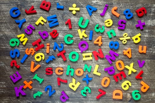 Background from colorful magnetic letters and numbers over a wooden background