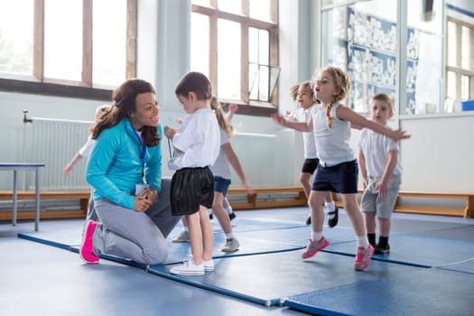 Nursery teacher reassuring one of her students during a physical education class.