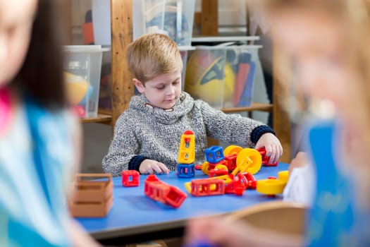 Young boy playing with building blocks at nursery.