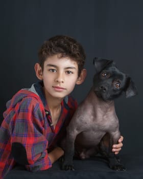 Portrait of Boy and Peruvian Dog on Black Background