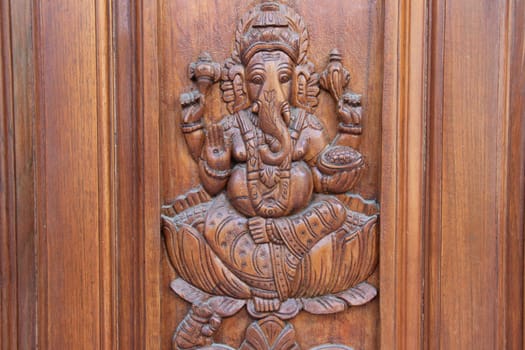 Bas relief etching of Ganesha on teakwood door panel
