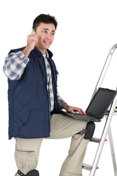 Decorator making telephone call whilst using laptop