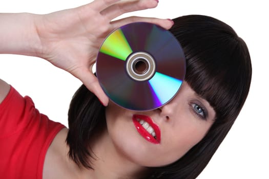 Woman holding a cd to an her eye