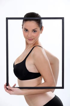 Brunette in bra holding picture frame