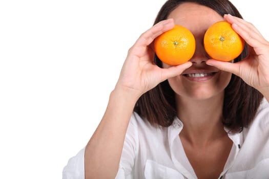 Woman using oranges for eyes