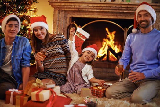 Family of four in Santa caps resting at home on Christmas evening