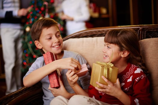 Glad boy and girl with Christmas presents in boxes