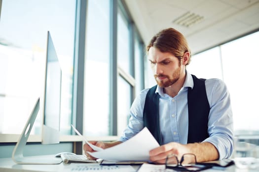 Serious employee working with papers in office