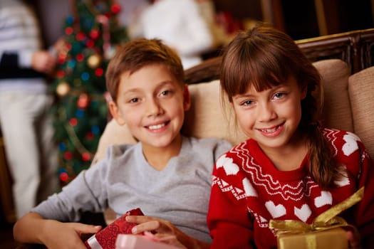 Adorable boy and girl with gifts looking at camera
