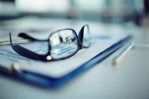 Clipboard with document, pen and eyeglasses