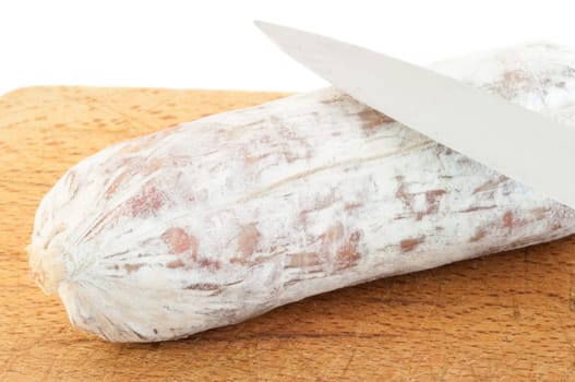 still life of salami whit knifeon a cutting board in studio