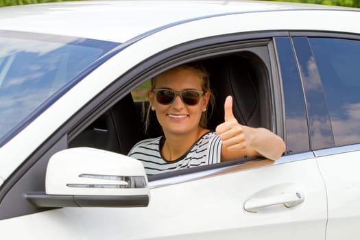 Young motorist with thumbs up