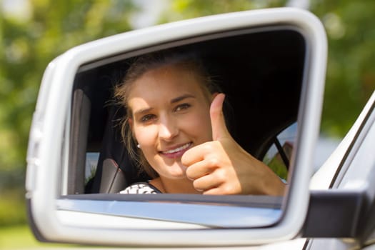 Young motorist with thumbs up