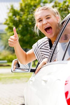 Young motorist with thumbs up