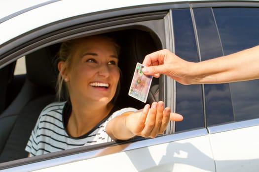Happy young motorist gets driver's license and car keys