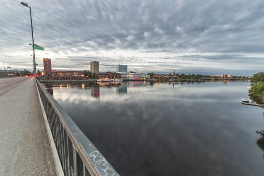 Downtown Umea, Sweden and its river with a cloudy sky.